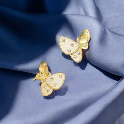 Elegant gold earrings with a butterfly design, featuring Mother of Pearl and sparkling Cubic Zirconia diamonds.